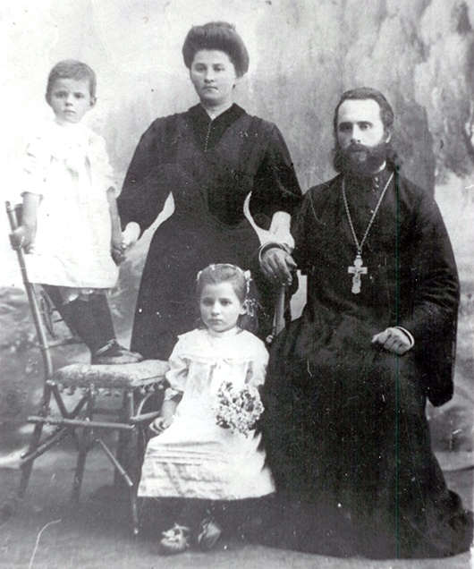 Святар Васіль Сцяпура з жонкай Ганнай і дочкамі Ірынай (стаіць на крэсле) і Лілай. 